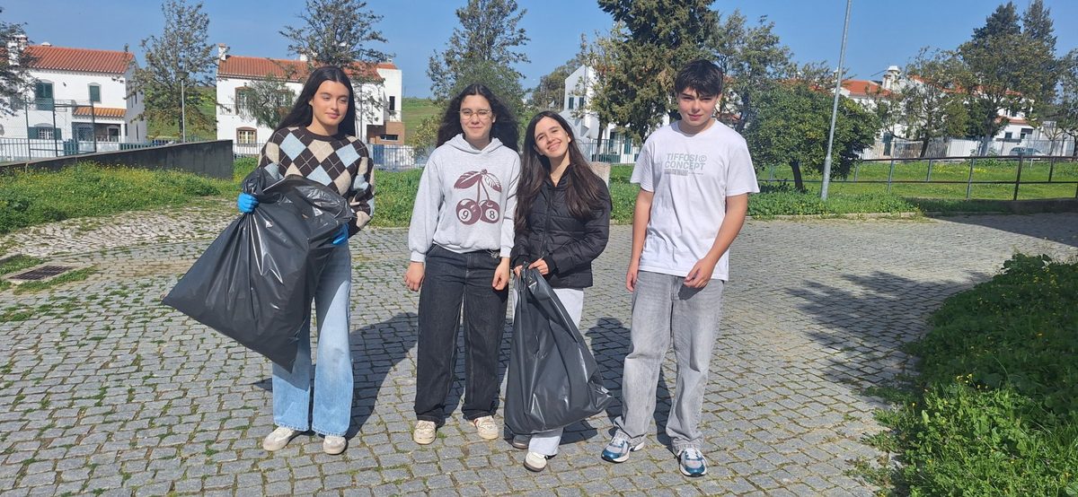 Grupo de quatro alunos com sacos cheios