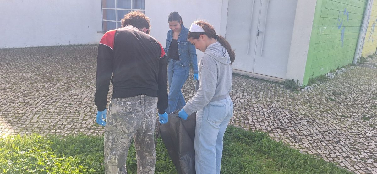Alunos a fechar um saco de lixo