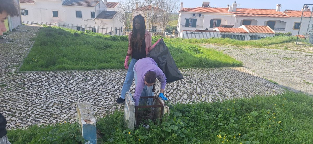 Alunos recolhendo resíduos junto a um poço