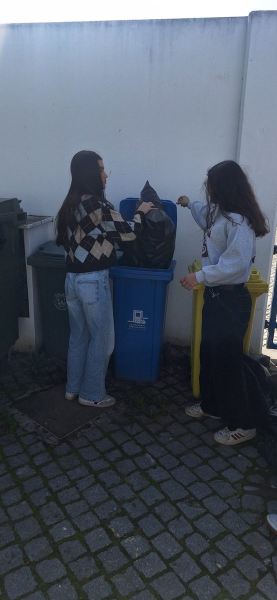 Duas alunas junto ao contentor azul
